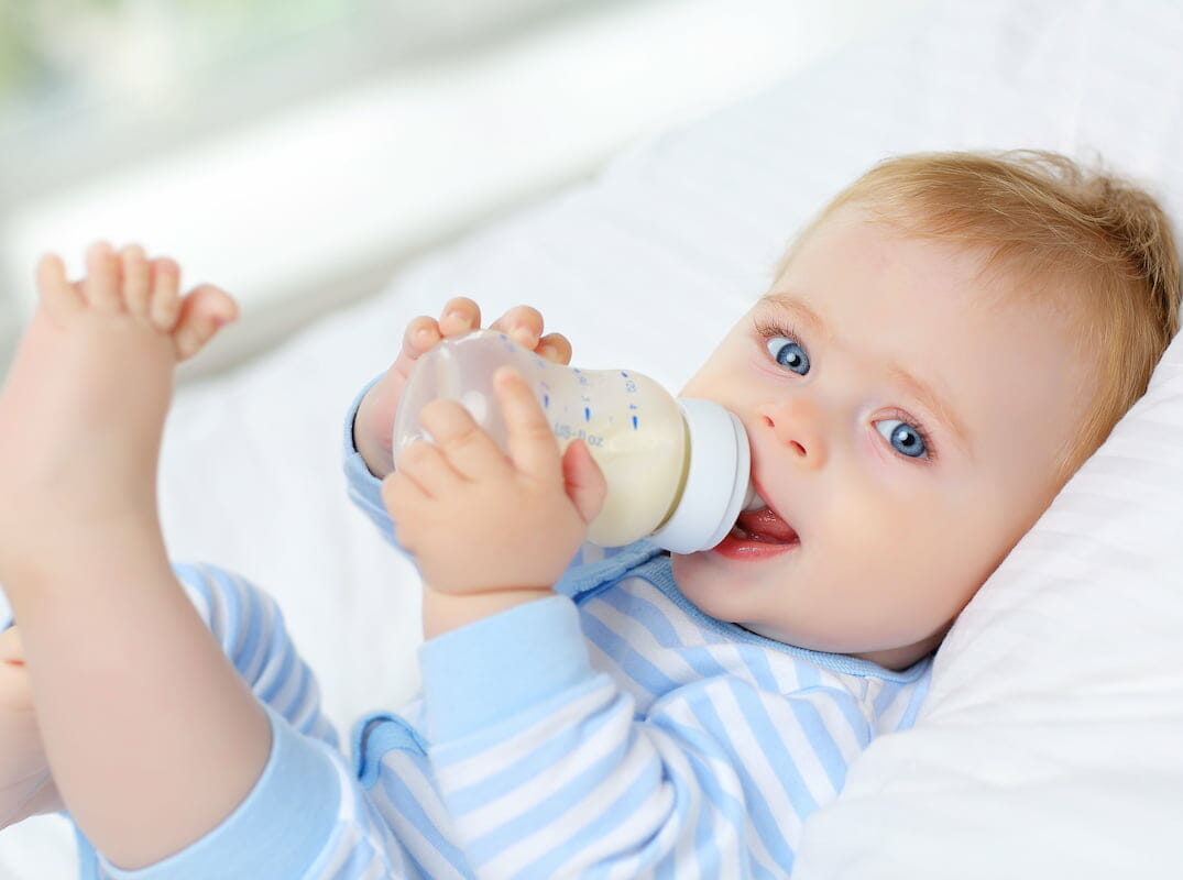 a baby drinking a bottle of milk