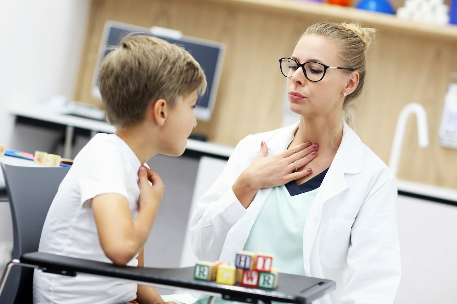 A paediatrician showing a child how speak