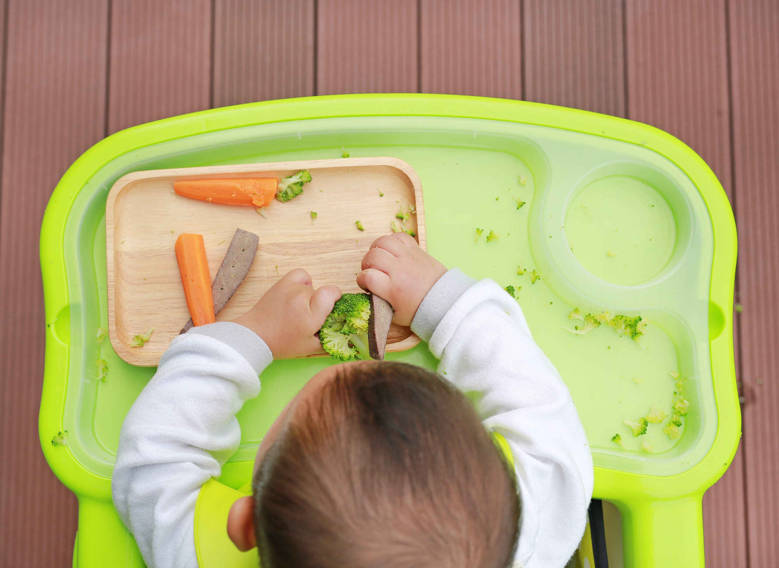 Top view of infant baby eating by Baby Led Weaning (BLW). Finger foods concept. Top view of infant baby eating by Baby Led Weaning (BLW). Finger foods concept.