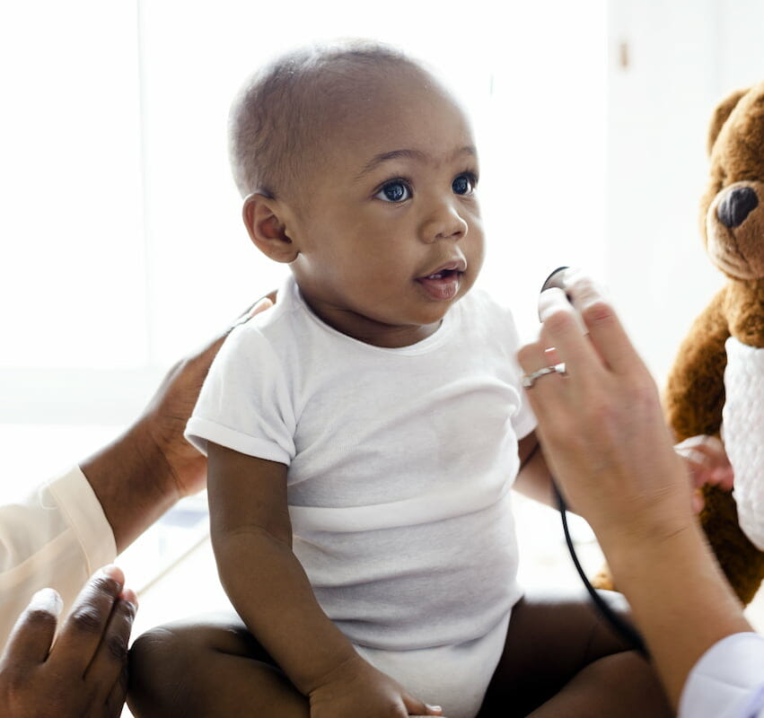 A doctor examining a baby with a stethoscope