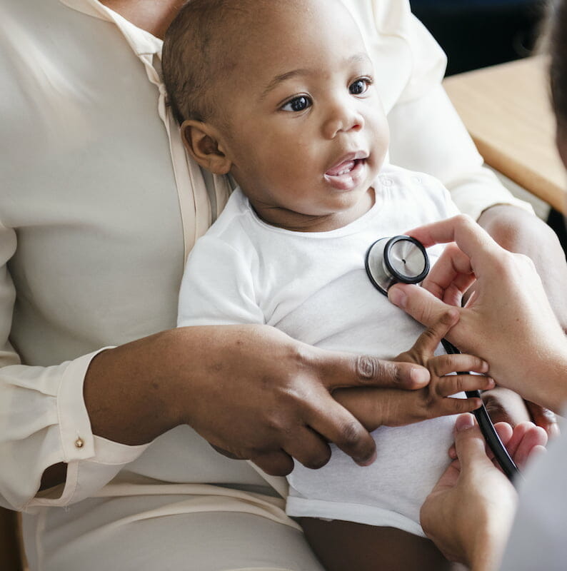a baby being examined with a stethoscope