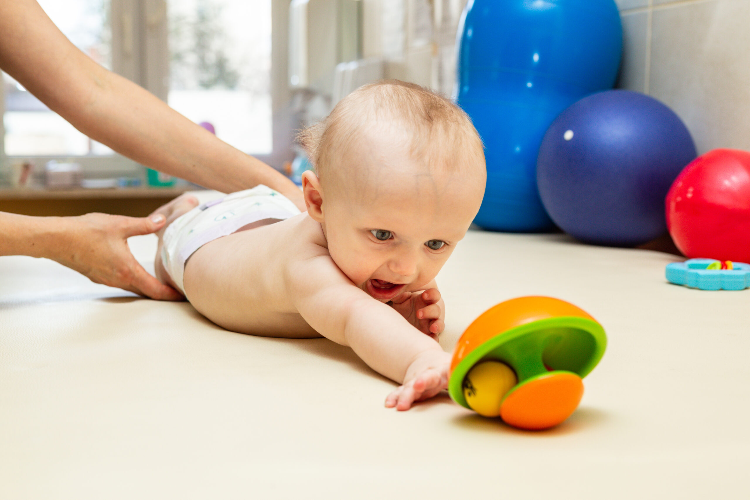Pediatric Physical Therapy - an infant exercising on a table