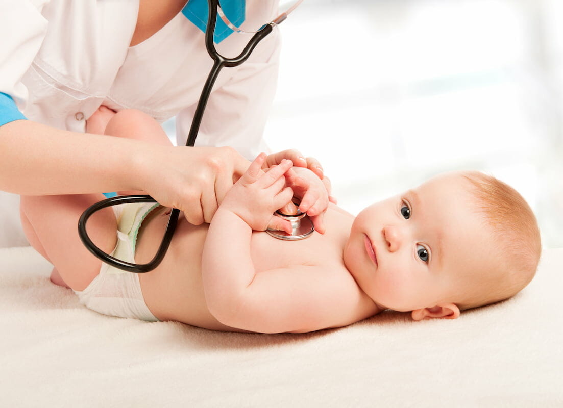 a baby being examined with a stethoscope