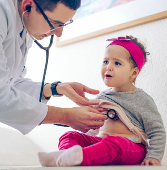 a child being examined by a paediatrician with a stethoscope