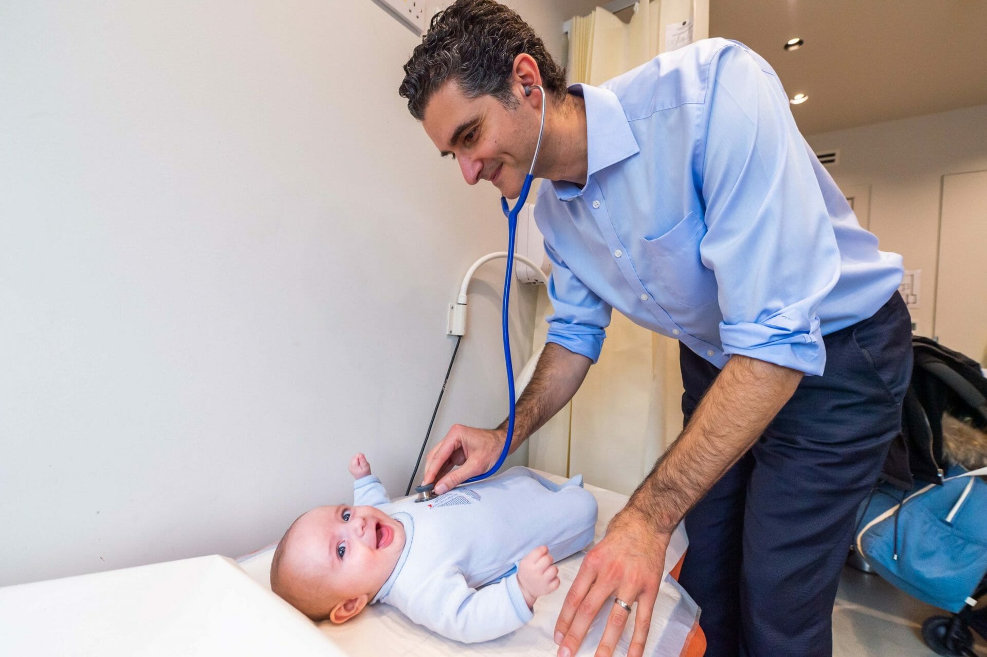 Dr. Yiannis examining a smiling baby