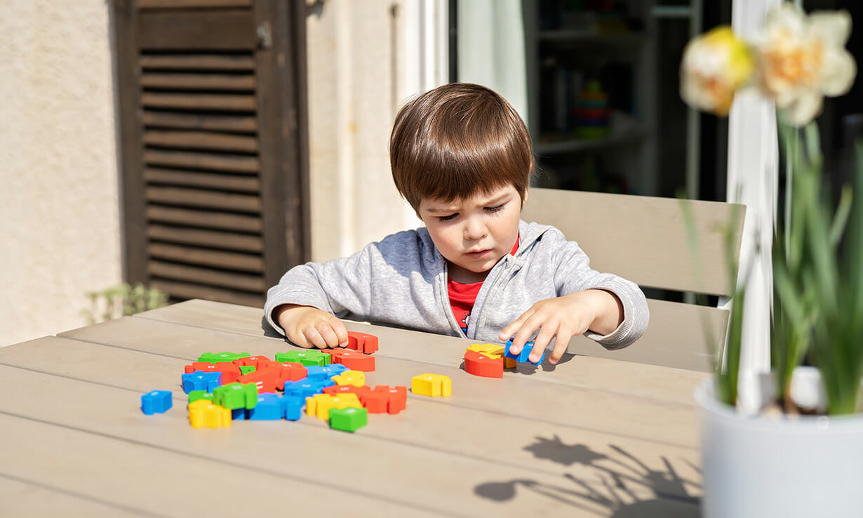 a toddler playing with puzzle blocks